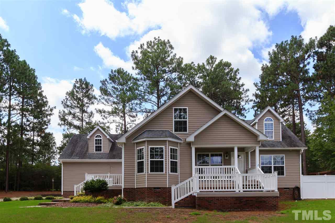 707 Sun Road Aberdeen, NC 28315 - Photo 1 of 23 a front view of a house with a garden and trees
