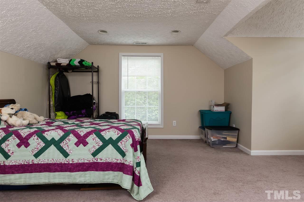 707 Sun Road Aberdeen, NC 28315 - Photo 19 of 23 a bedroom with a bed and a chandelier