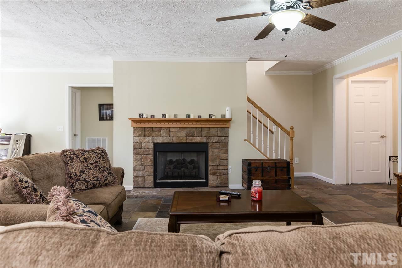 707 Sun Road Aberdeen, NC 28315 - Photo 4 of 23 a living room with furniture a fireplace and a flat screen tv