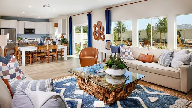 a living room with furniture kitchen view and a large window