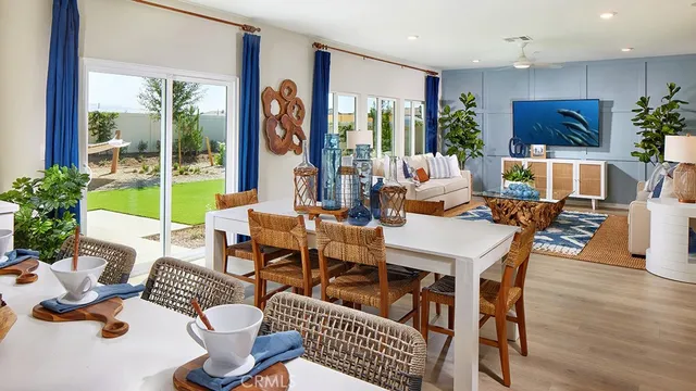 a view of a dining room and livingroom with furniture wooden floor and a large window