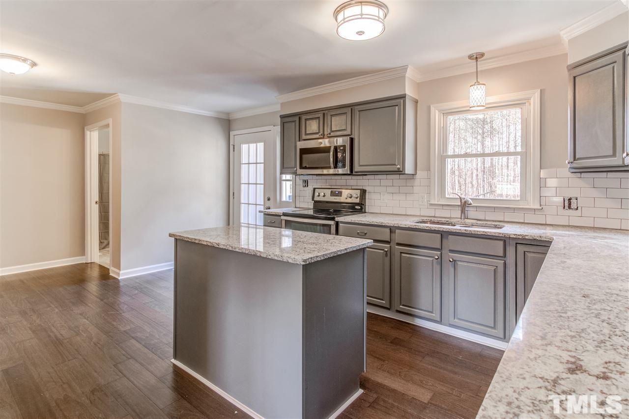 3317 Broughton Road Wendell, NC 27591 - Photo 4 of 11 a kitchen with stainless steel appliances granite countertop a sink cabinets and a wooden floor