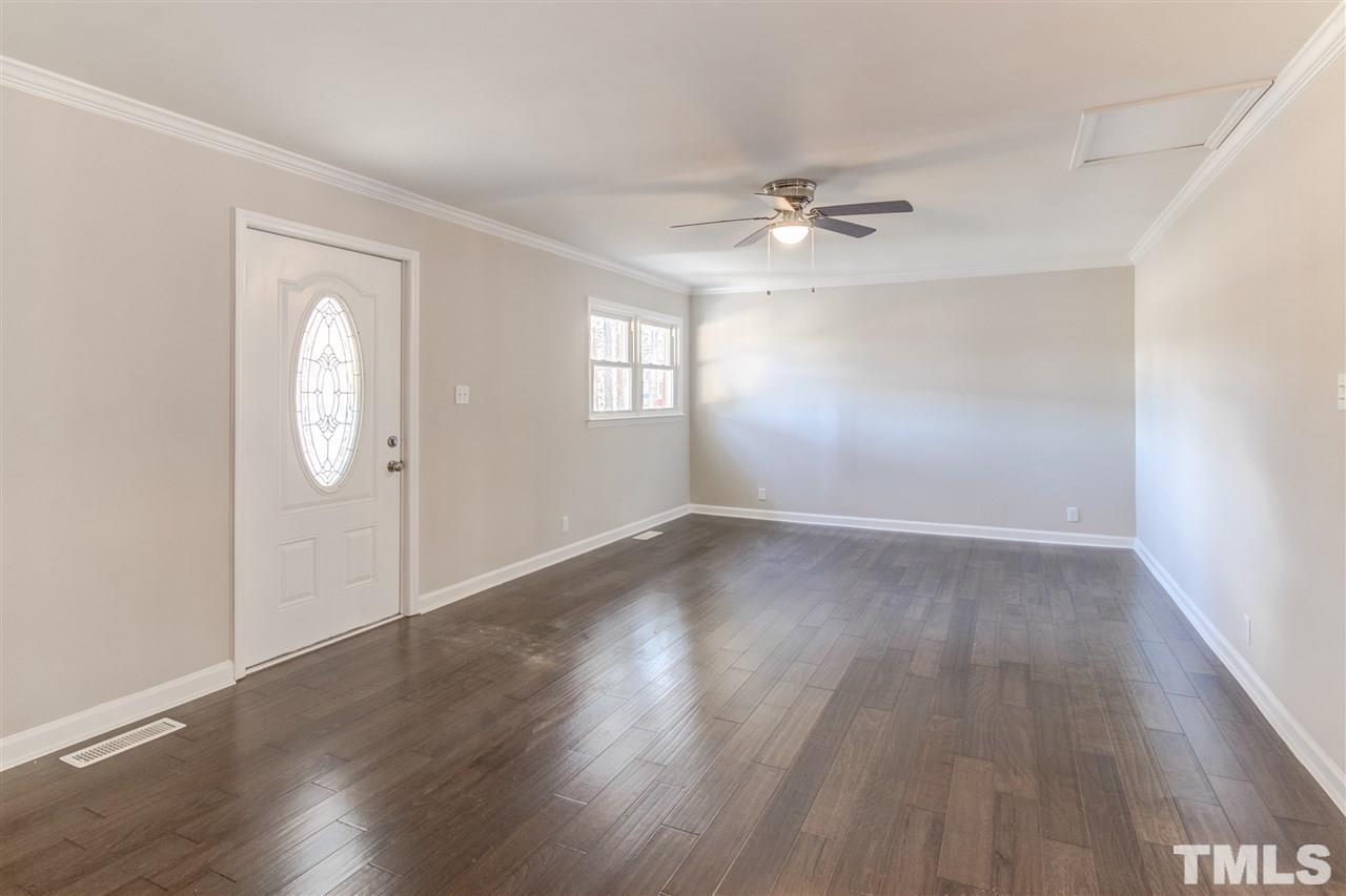 3317 Broughton Road Wendell, NC 27591 - Photo 6 of 11 an empty room with wooden floor ceiling fan and windows