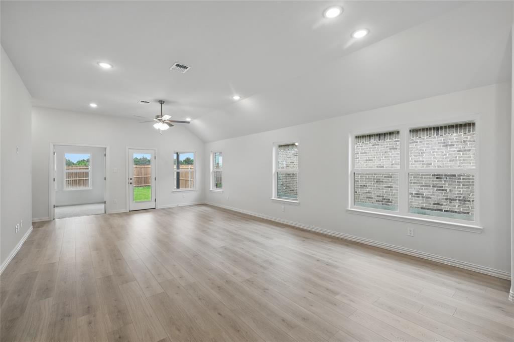 949 Schuberts Road Justin, TX 76247 - Photo 7 of 24 Unfurnished living room with a ceiling fan, lofted ceiling, light wood finished floors, and recessed lighting