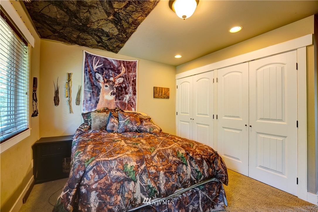 1290 West Axton Road Ferndale, WA 98248 - Photo 27 of 36 a bed sitting in a bedroom next to a window
