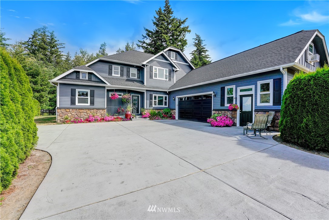 1290 West Axton Road Ferndale, WA 98248 - Photo 4 of 36 a front view of a house with a yard and garage