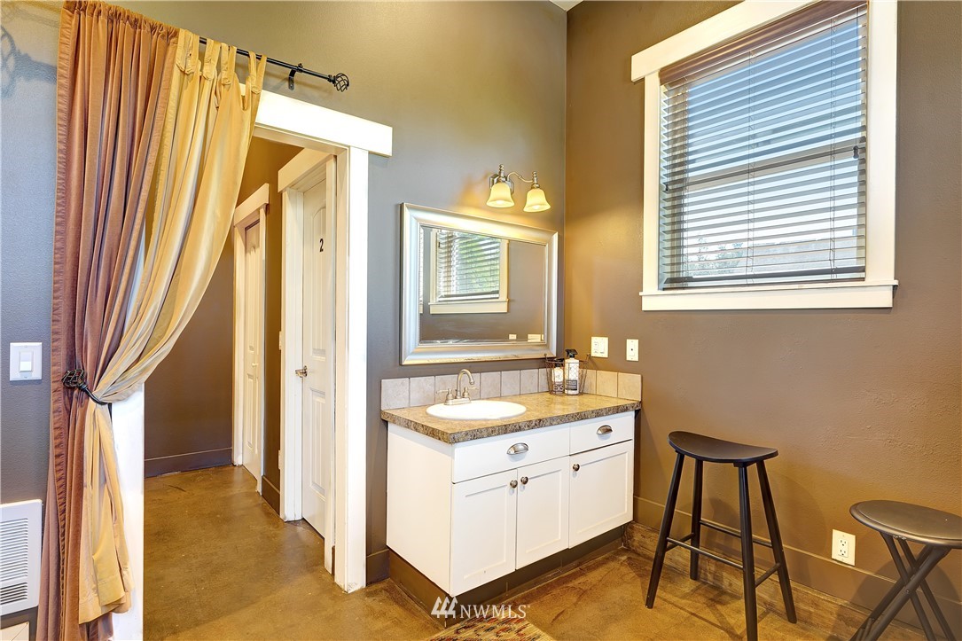 1290 West Axton Road Ferndale, WA 98248 - Photo 32 of 36 a en suite bathroom with a granite countertop sink a mirror and a bathtub
