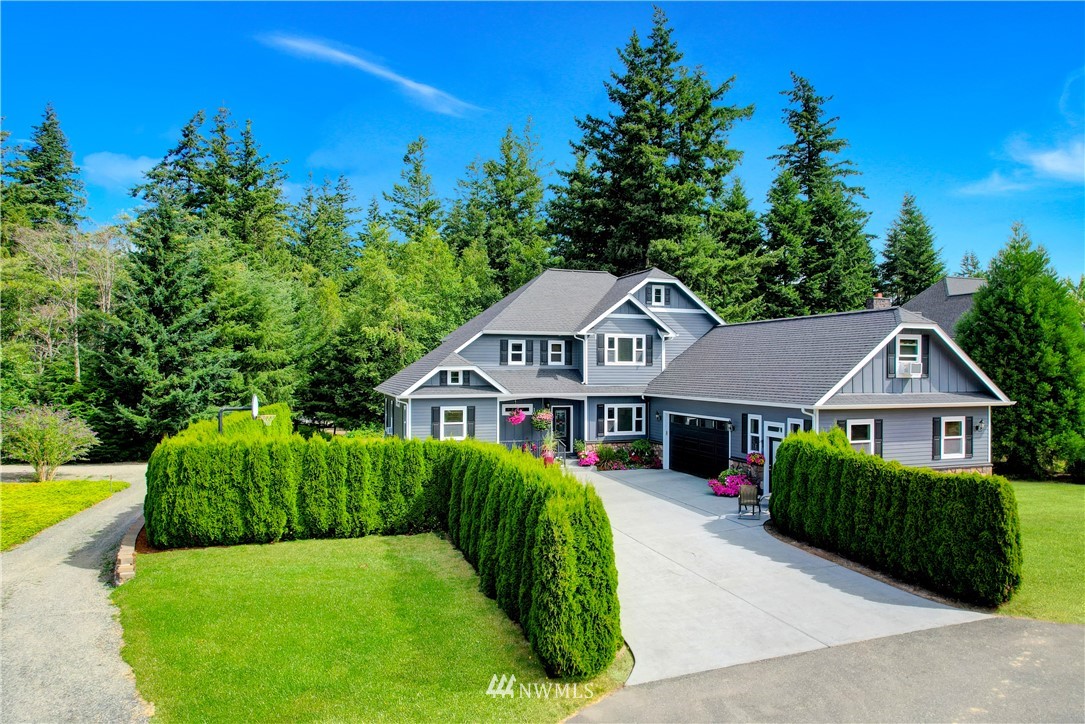 1290 West Axton Road Ferndale, WA 98248 - Photo 5 of 36 a view of a white house with a big yard plants and large trees
