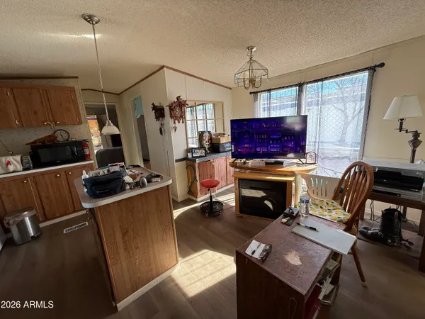 a living room with furniture a flat screen tv and a refrigerator