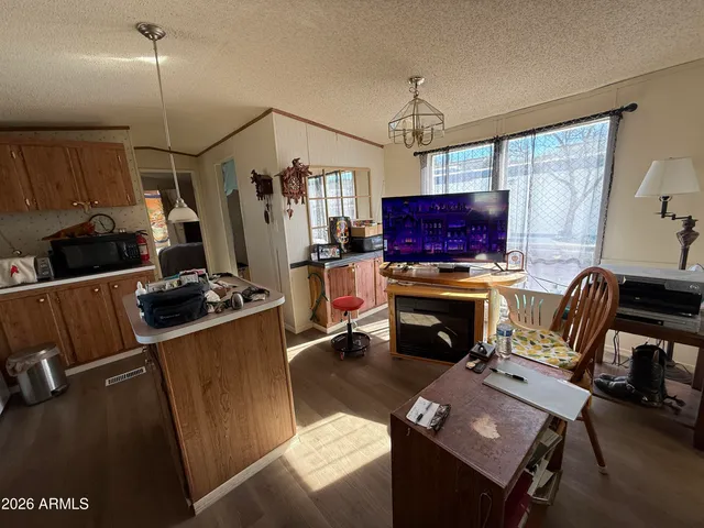 a living room with furniture a flat screen tv and a refrigerator