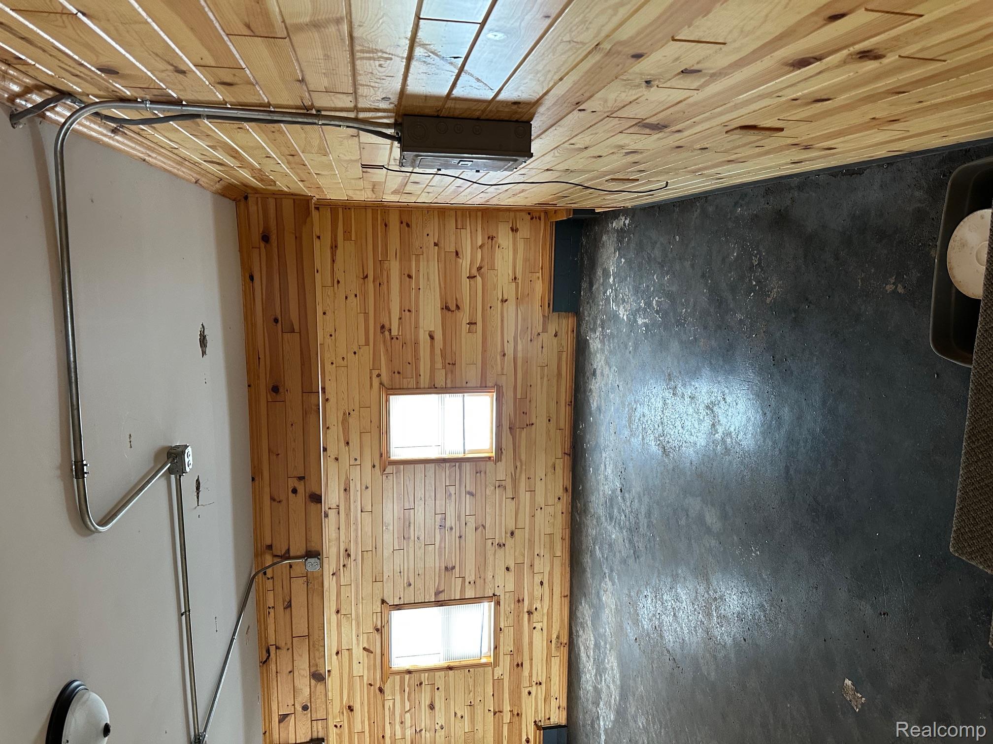 3803 Warner Road Cass City, MI 48726 - Photo 43 of 85 Spare room featuring wooden walls, concrete floors, and healthy amount of natural light