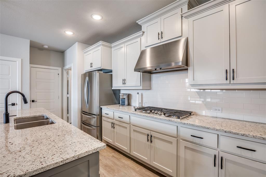 6420 Trezevant Street Rowlett, TX 75089 - Photo 10 of 28 Kitchen has granite, subway tile, and premium stainless appliances including gas cooktop