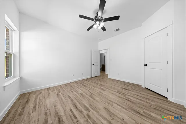 a view of empty room with wooden floor