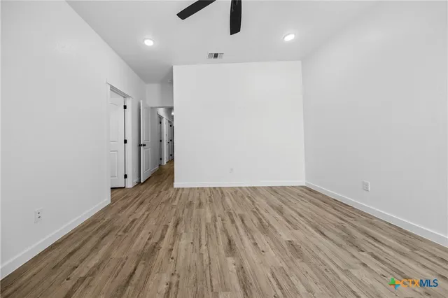 a view of a room with wooden floor staircase and a kitchen
