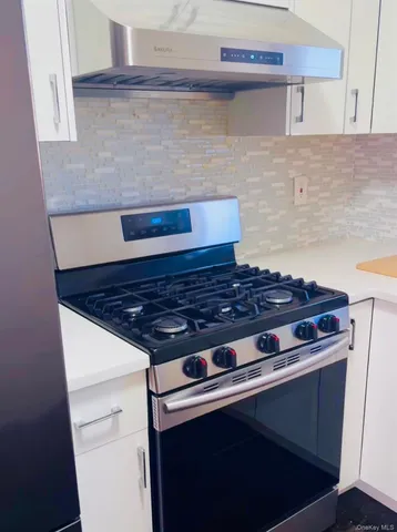 a stove top oven sitting inside of a kitchen