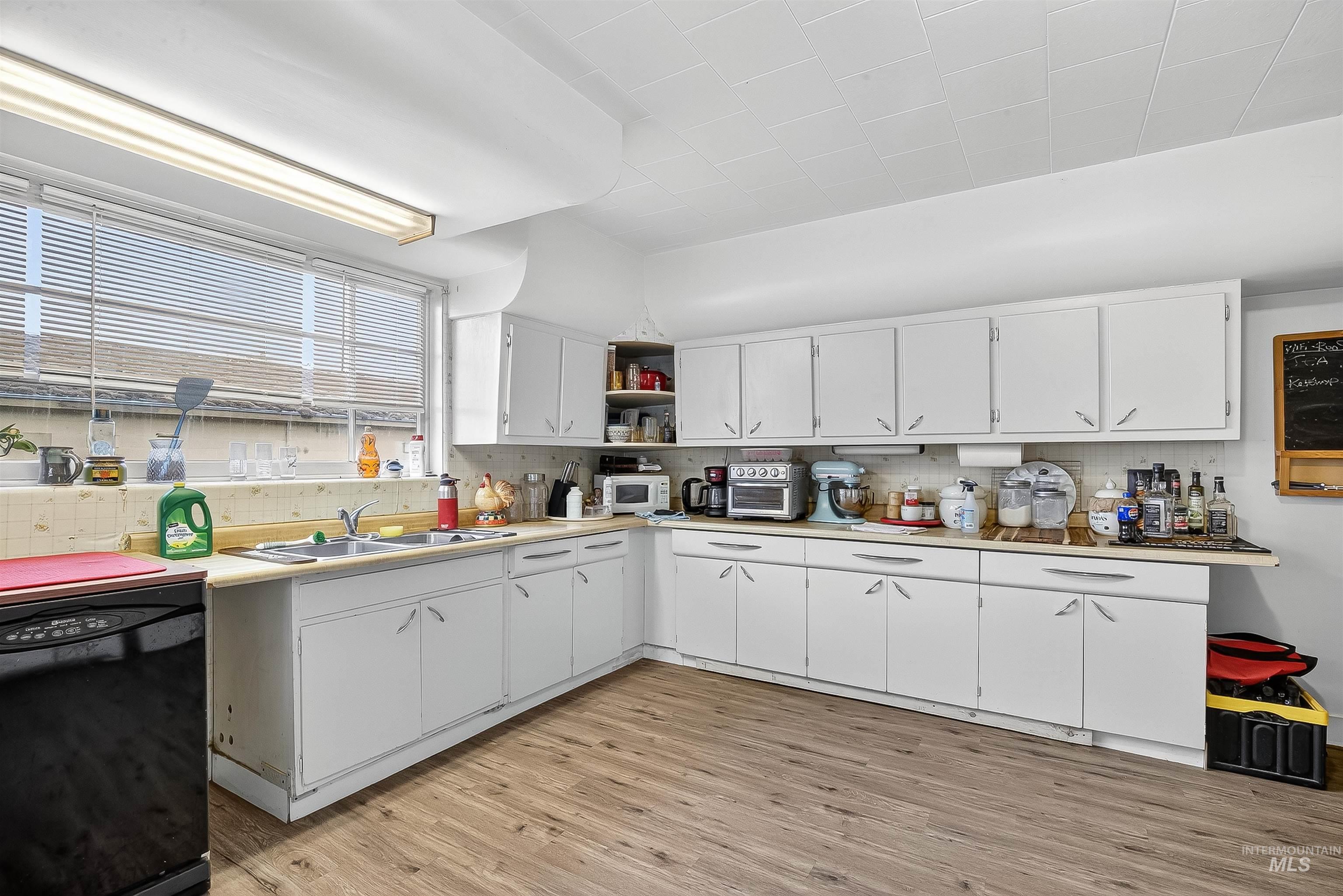 705 28th Street North Lewiston, ID 83501 - Photo 16 of 34 Kitchen with light countertops, black dishwasher, white cabinets, light wood finished floors, and open shelves