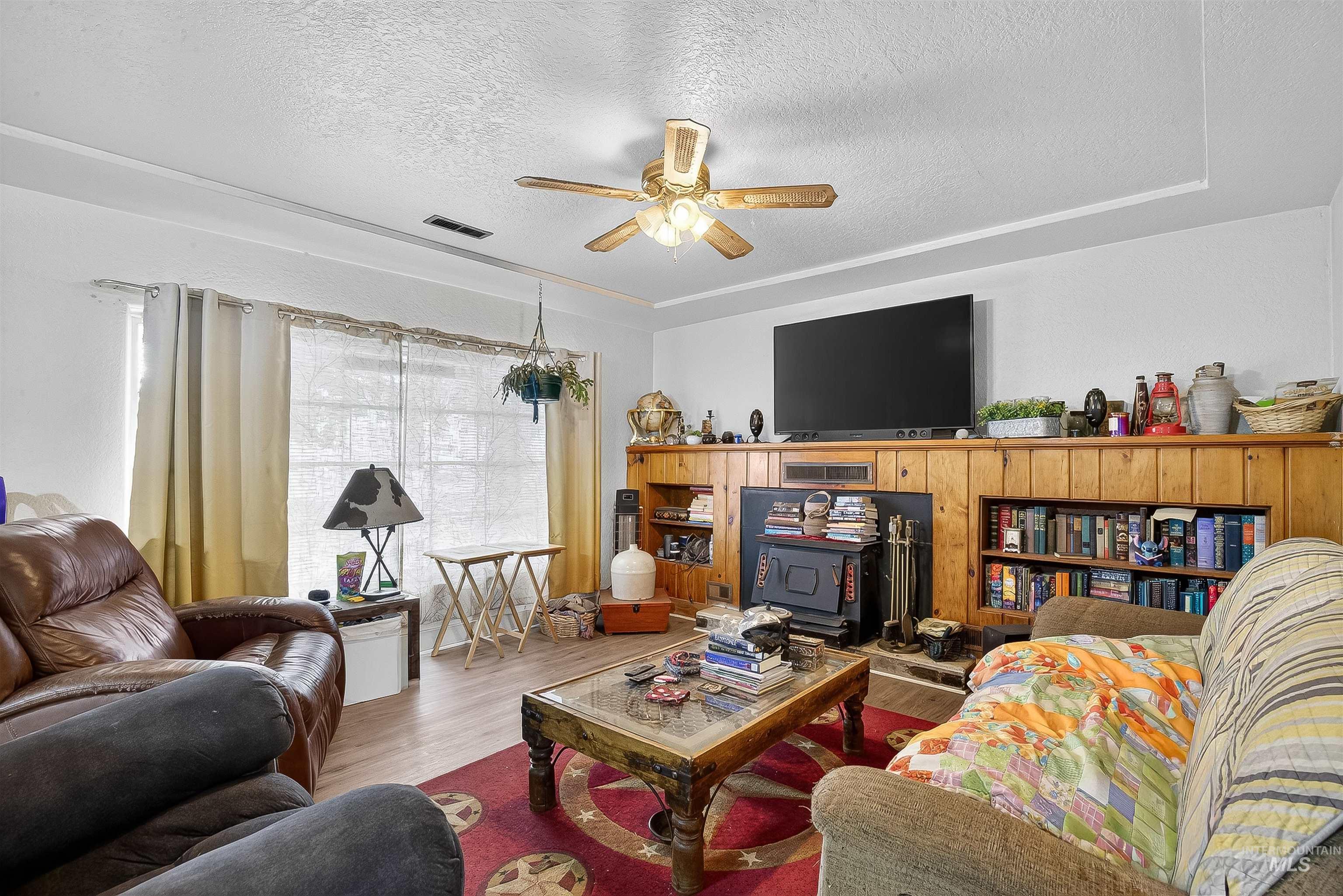 705 28th Street North Lewiston, ID 83501 - Photo 10 of 34 Living room with wood finished floors, a textured ceiling, and a ceiling fan