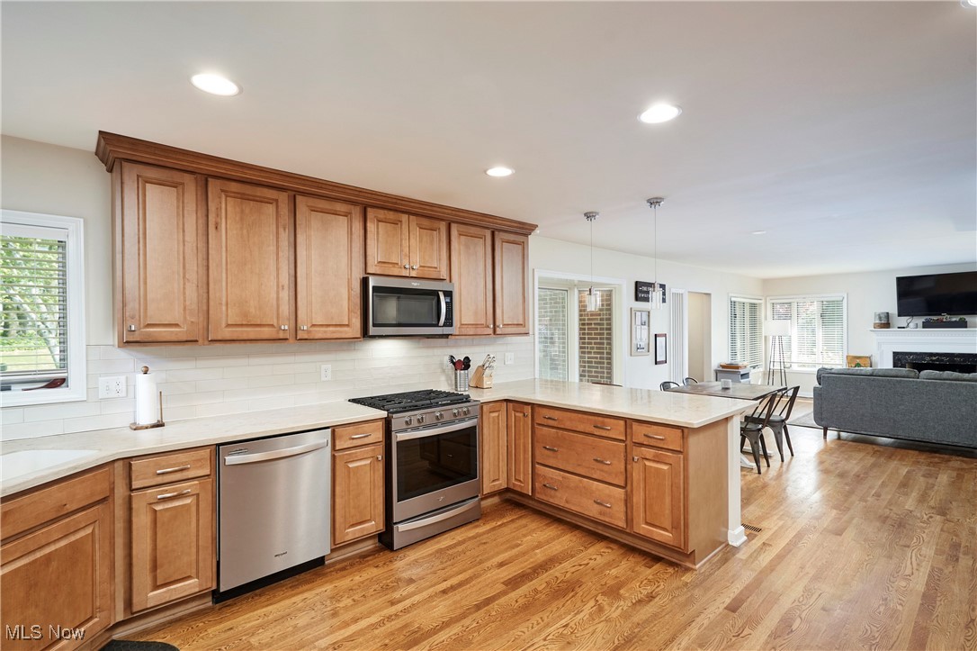 2530 Holgate Road Akron, OH 44313 - Photo 13 of 31 Kitchen with appliances with stainless steel finishes, a peninsula, tasteful backsplash, light wood-style flooring, and recessed lighting