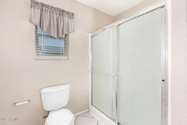 an empty room with a window and a ceiling fan