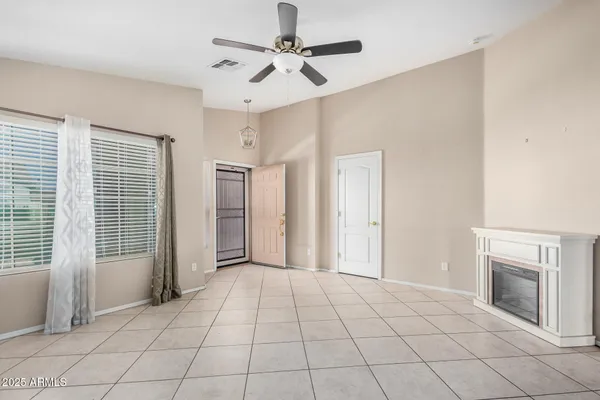 an empty room with fan and windows