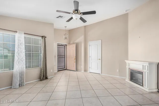 an empty room with fan and windows