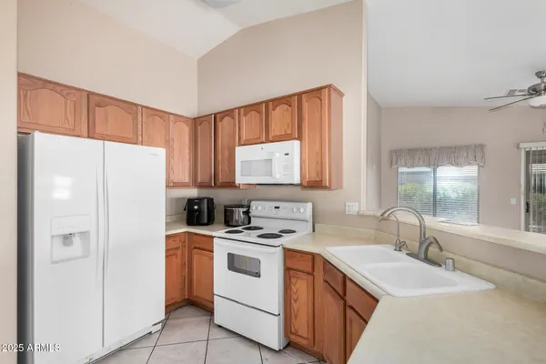a kitchen with white cabinets sink and white appliances