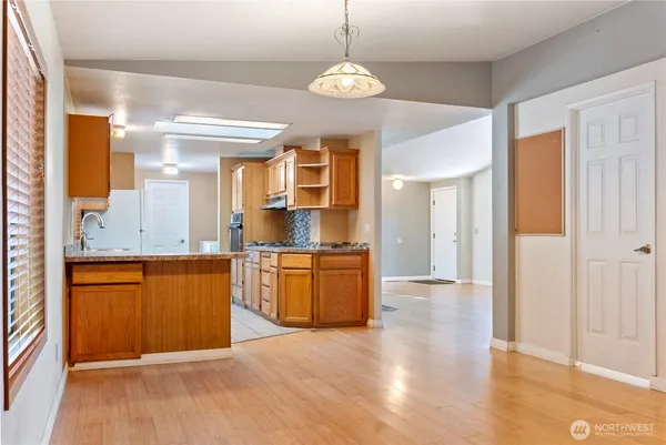 a kitchen with stainless steel appliances kitchen island granite countertop a refrigerator and a sink
