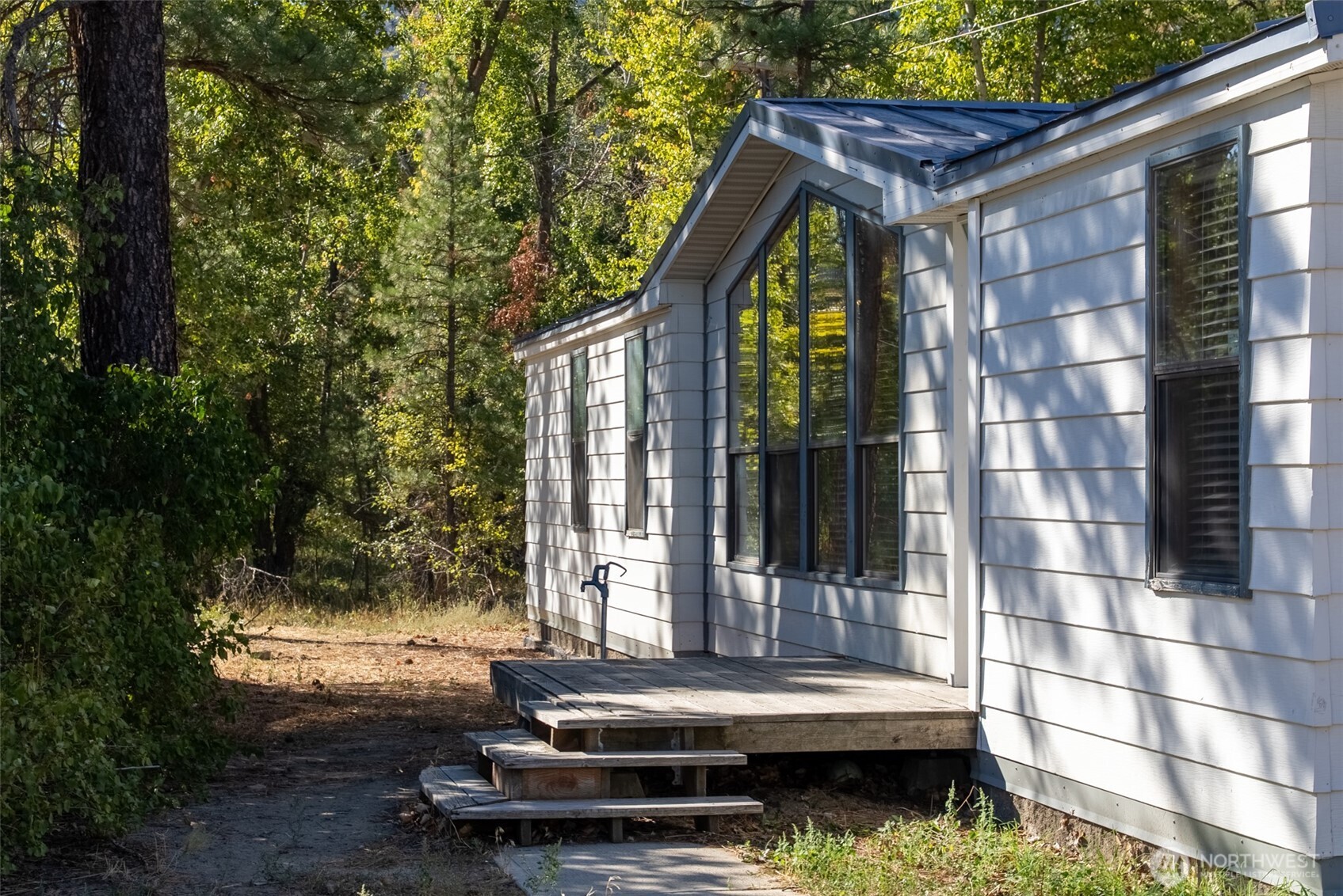 1221 Riverside Avenue Twisp, WA 98856 - Photo 2 of 40 a backyard of a house with barbeque oven and outdoor seating