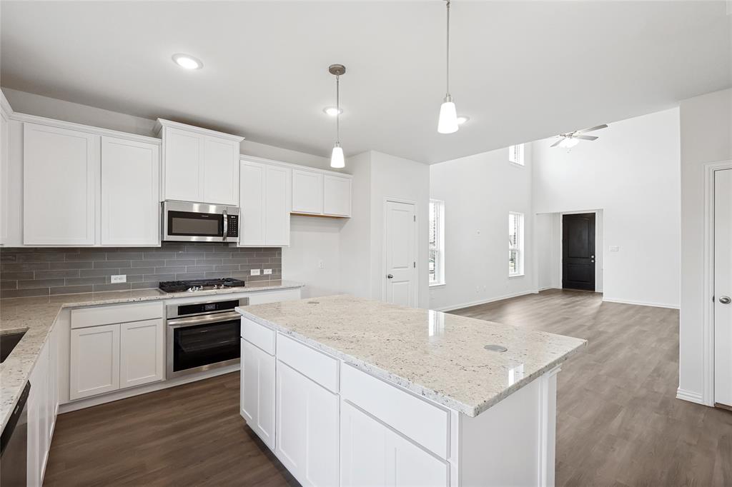 3900 Coco Lane Sherman, TX 75090 - Photo 3 of 40 Kitchen with a center island, hanging light fixtures, white cabinets, stainless steel appliances, and backsplash