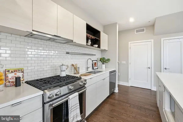 a white stove top oven sitting inside of a kitchen