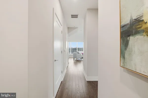 a view of a hallway with wooden floor windows and a livingroom