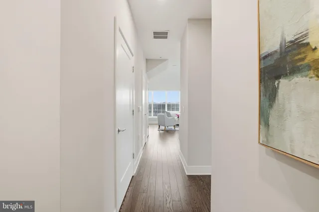 a view of a hallway with wooden floor windows and a livingroom