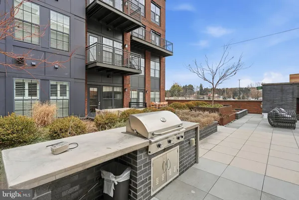 a view of a patio with table and chairs and barbeque oven