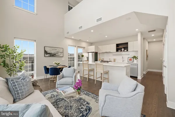 a living room with furniture and a dining table with kitchen view