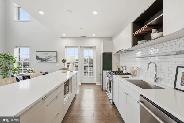 a large kitchen with stainless steel appliances lots of counter space and wooden floor