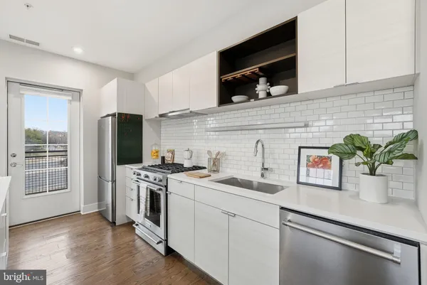 a kitchen with stainless steel appliances white cabinets and a stove top oven