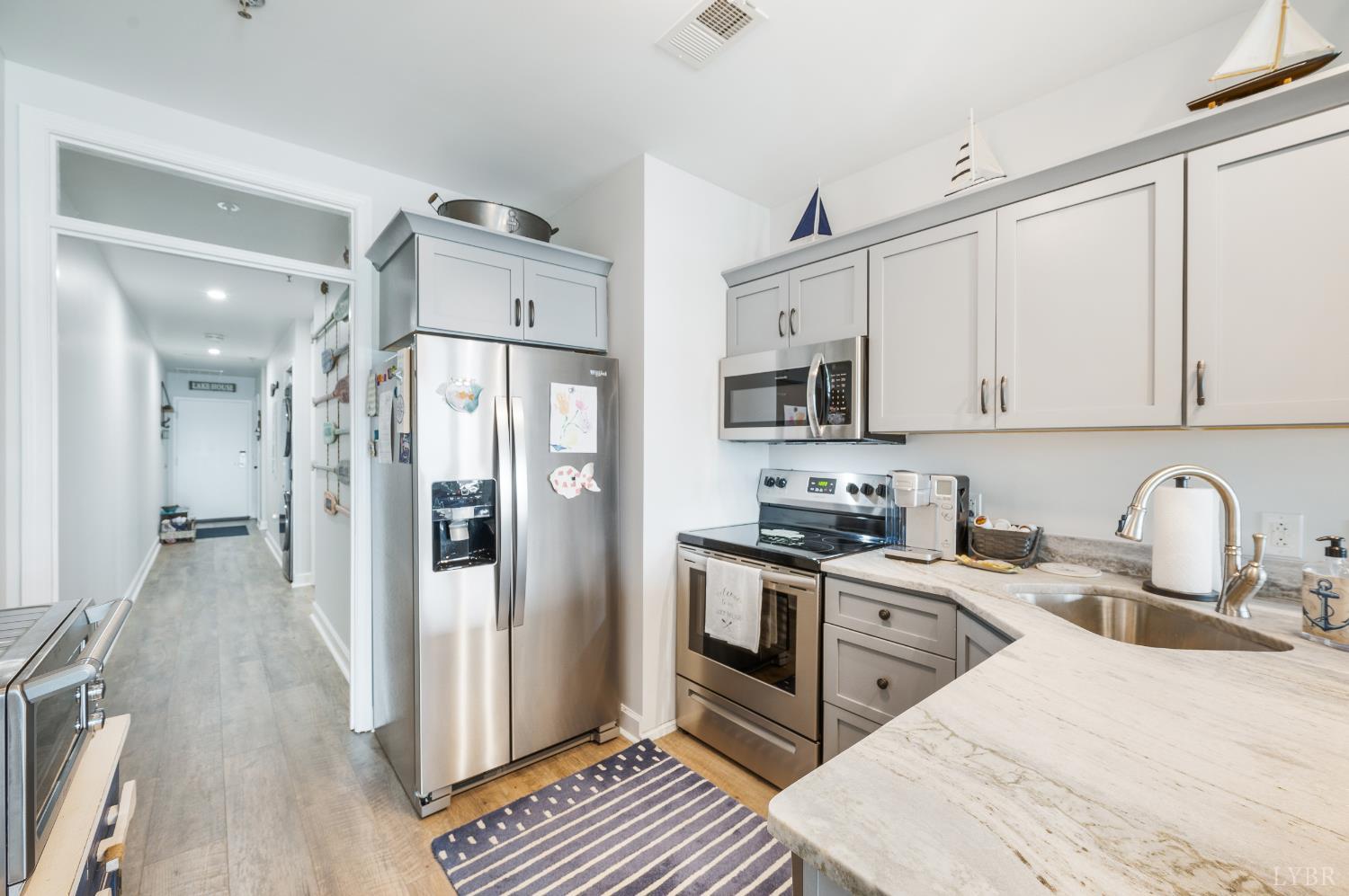 1245 Graves Harbor Trail, Unit 212 Huddleston, VA 24104 - Photo 20 of 60 a kitchen with stainless steel appliances granite countertop a refrigerator a stove a sink and white cabinets with wooden floor