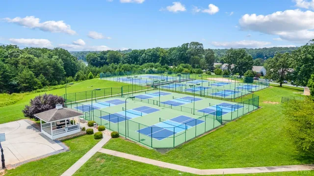 a view of a building with a big yard and large trees