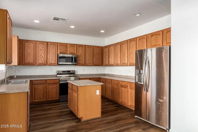 a kitchen with stainless steel appliances granite countertop wooden cabinets a stove top oven a sink and dishwasher