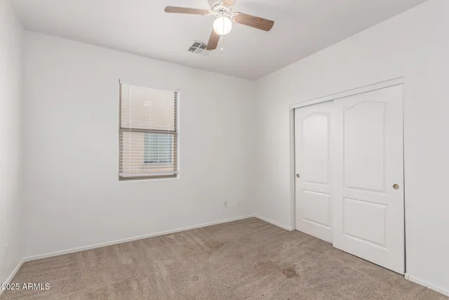 an empty room with a ceiling fan and painted walls