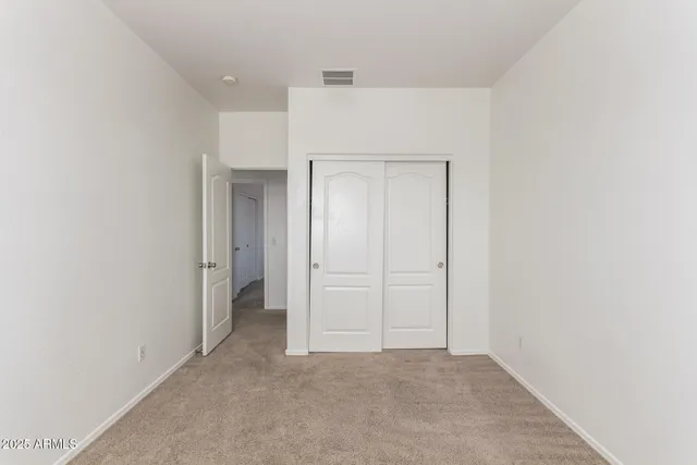 an empty room with a window and a ceiling fan