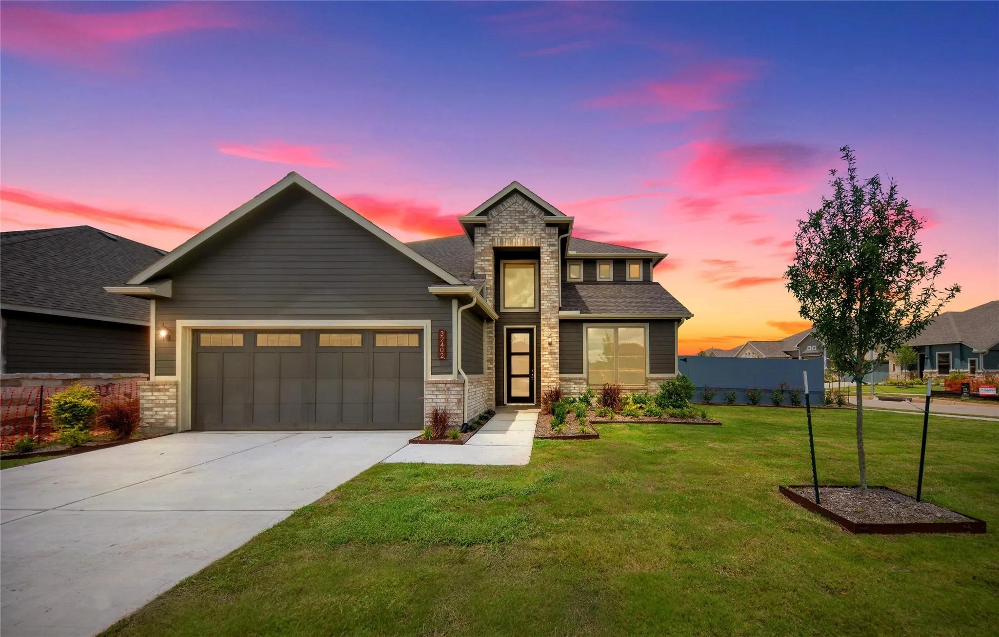 a front view of a house with a yard and garage