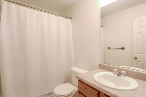 a bathroom with a sink a toilet and a mirror
