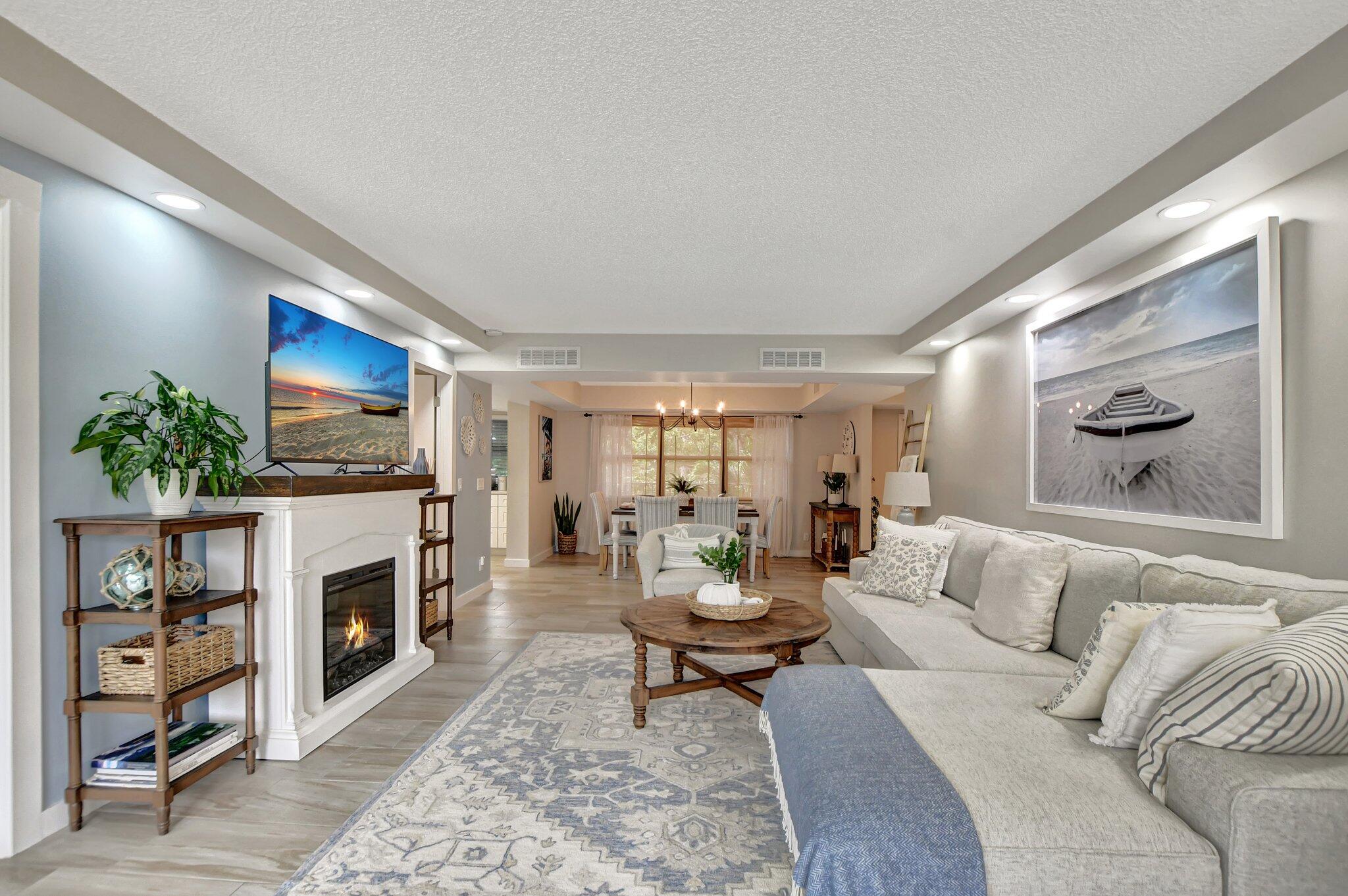 277 North Ocean Boulevard, Unit 3010 Boca Raton, FL 33432 - Photo 15 of 37 a living room with furniture a flat screen tv and a fireplace