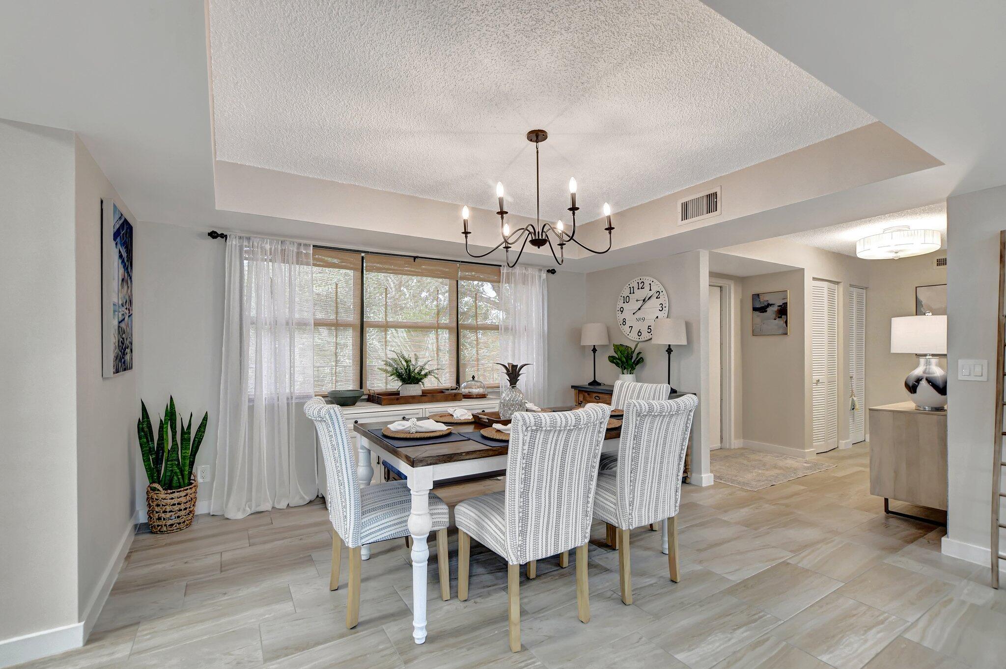 277 North Ocean Boulevard, Unit 3010 Boca Raton, FL 33432 - Photo 16 of 37 a dining room with furniture potted plants and wooden floor