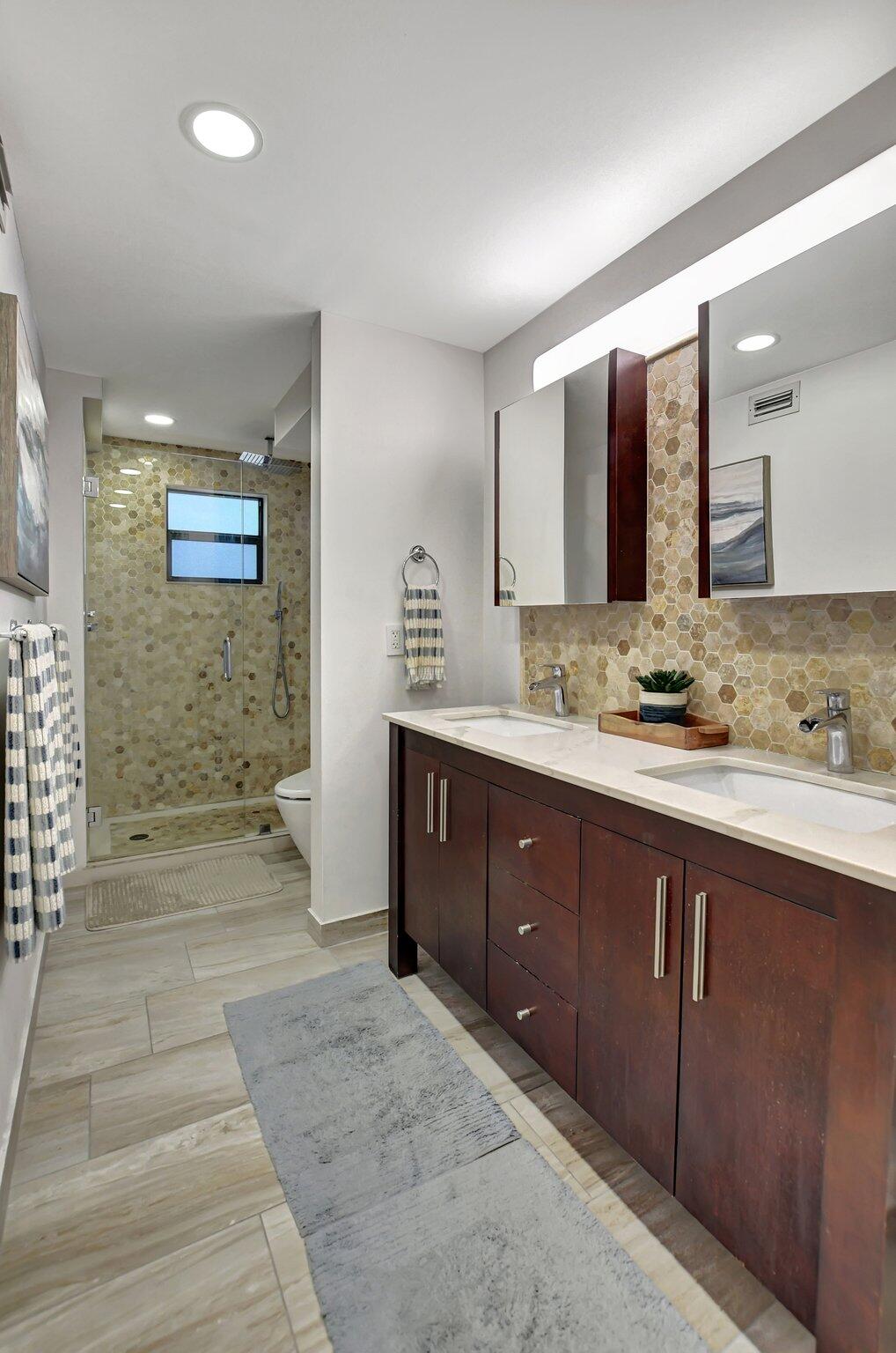 277 North Ocean Boulevard, Unit 3010 Boca Raton, FL 33432 - Photo 24 of 37 a spacious bathroom with a granite countertop double vanity sink a mirror and a shower