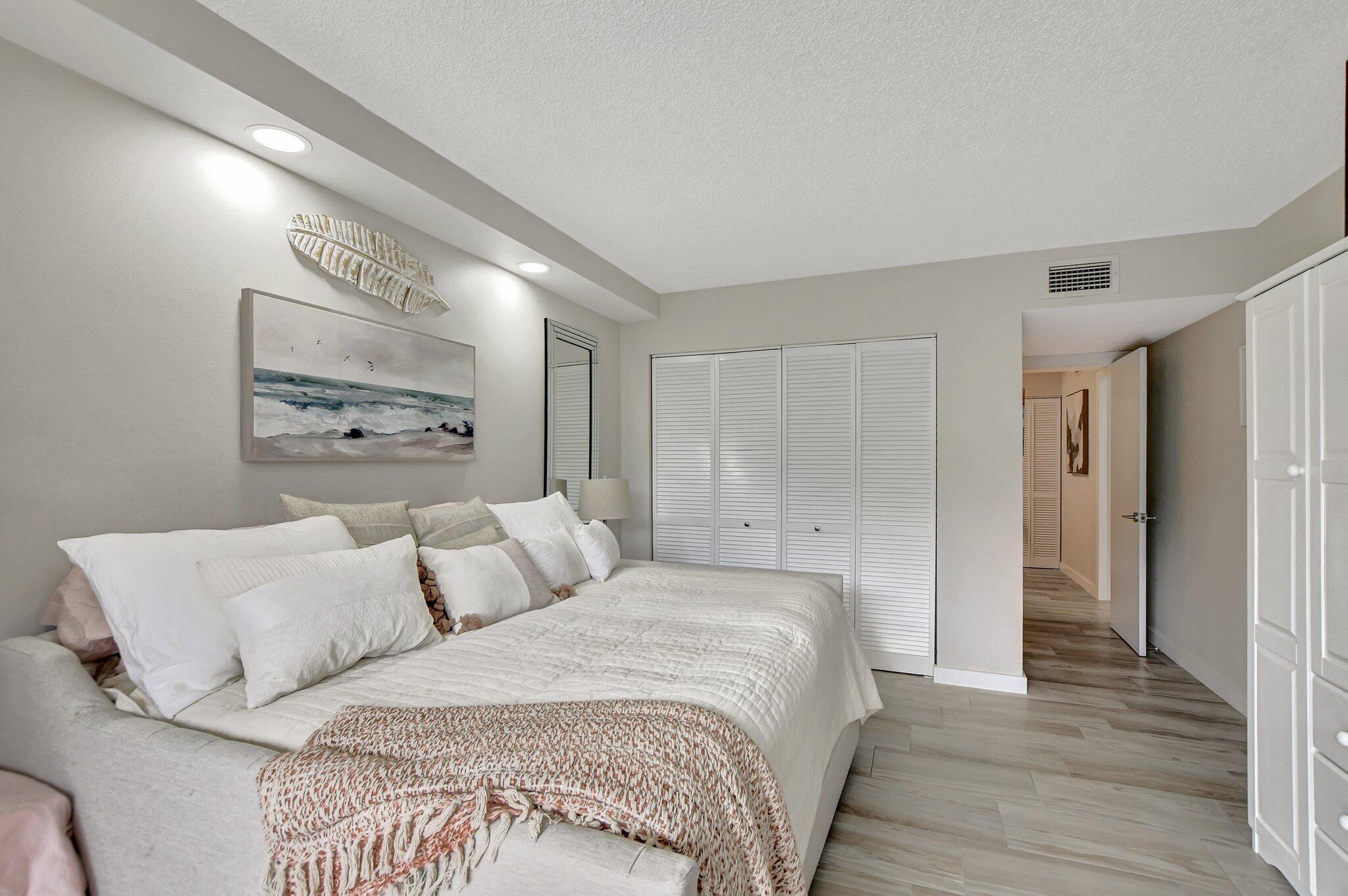 277 North Ocean Boulevard, Unit 3010 Boca Raton, FL 33432 - Photo 28 of 37 a spacious bedroom with a bed and a painting on the wall