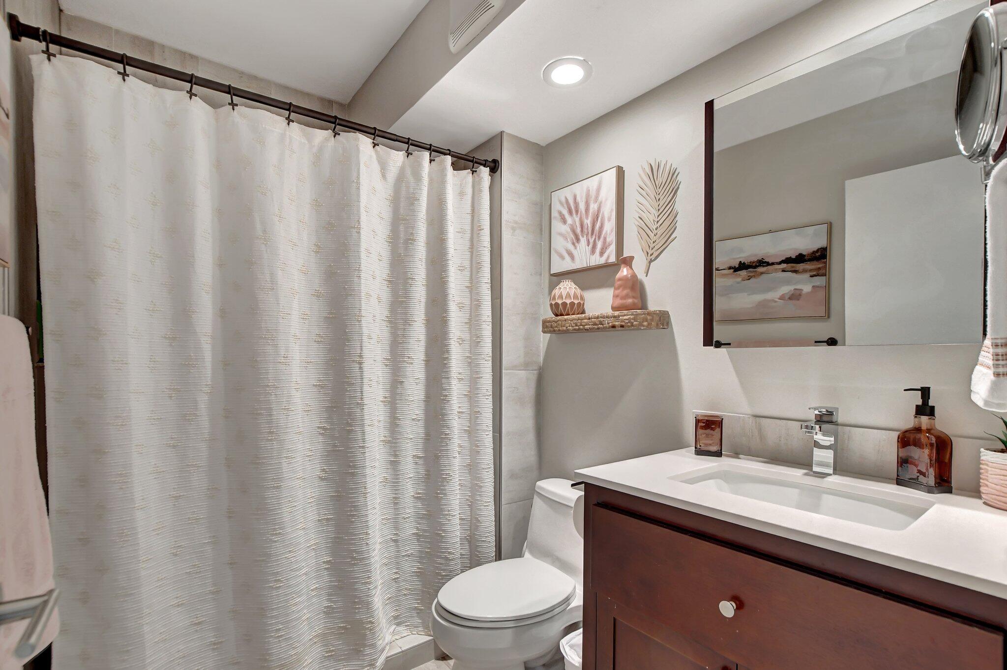 277 North Ocean Boulevard, Unit 3010 Boca Raton, FL 33432 - Photo 29 of 37 a bathroom with a granite countertop sink toilet and a mirror