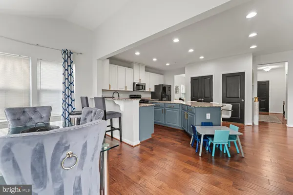 a kitchen with a dining table chairs refrigerator and microwave