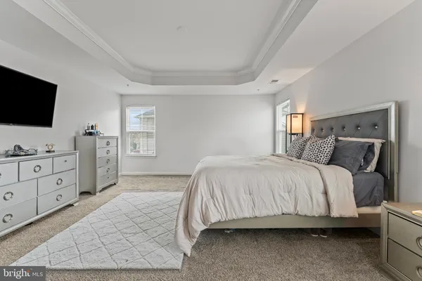 a spacious bedroom with a bed and a flat screen tv